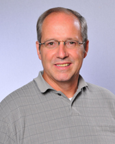 Dave's professional headshot wearing a grey collared shirt