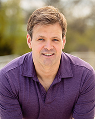 Will's professional headshot wearing a purple collared shirt