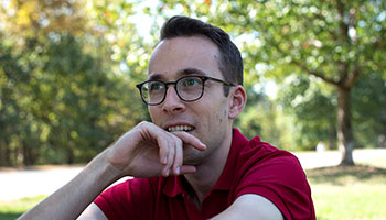 Roel's headshot wearing eye glasses and a red collared shirt 
