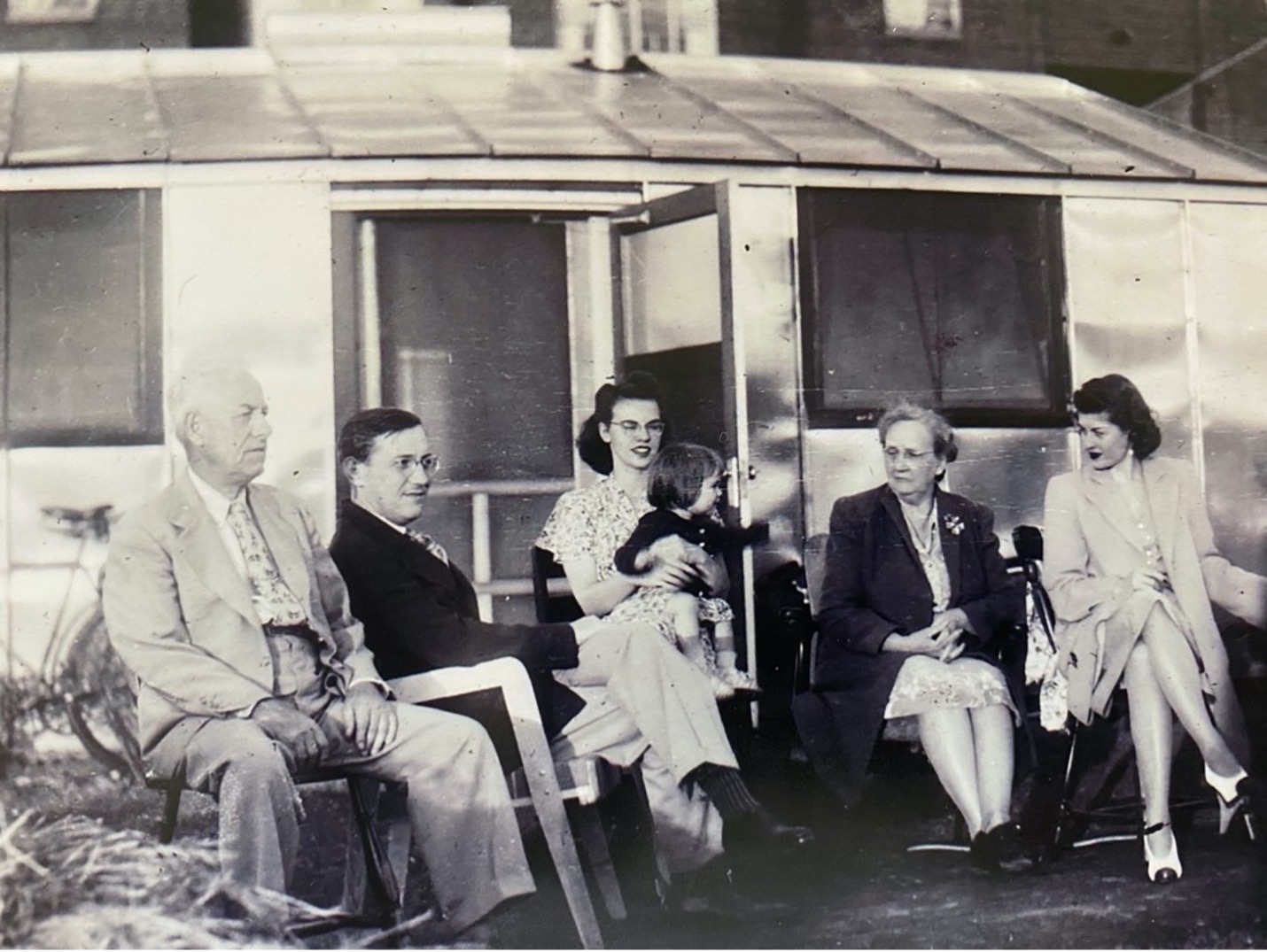 Robert Letsinger's family sitting in front of his tin hut