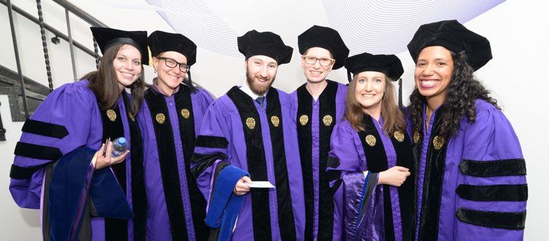 Chemistry doctoral candidates pose for a picture at their graduation ceremony